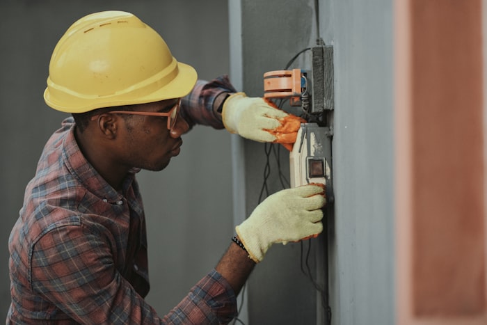 Électricien installant un équipement électrique mural